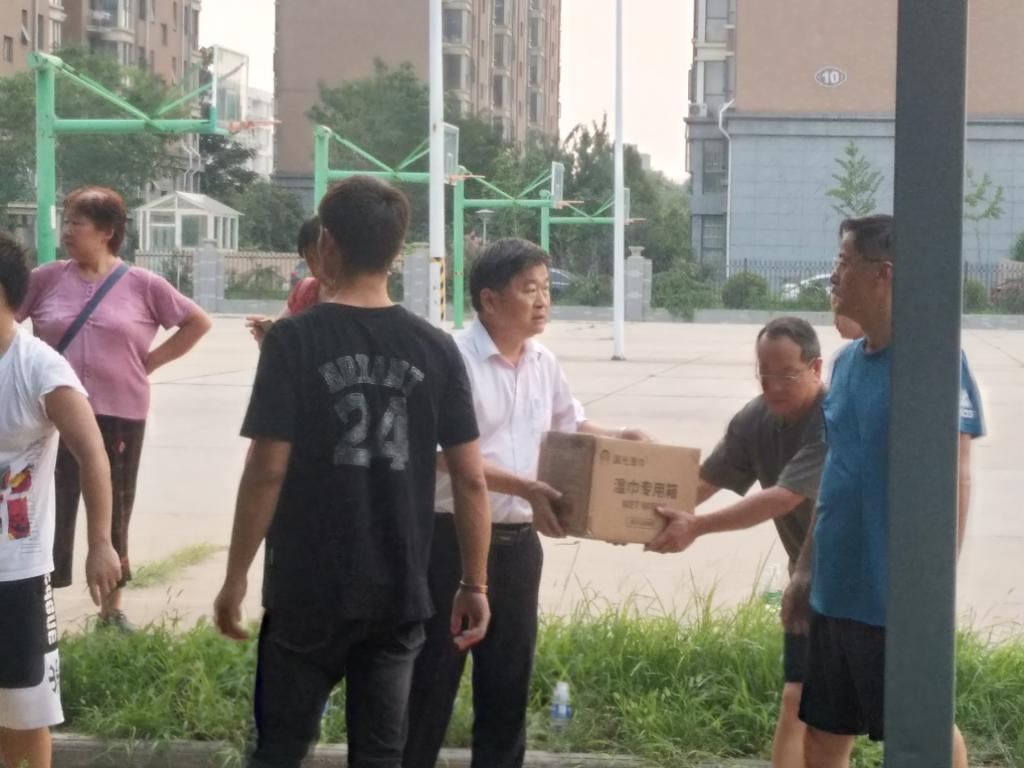 副校长王孝俊与志愿者一同搬运捐赠物资