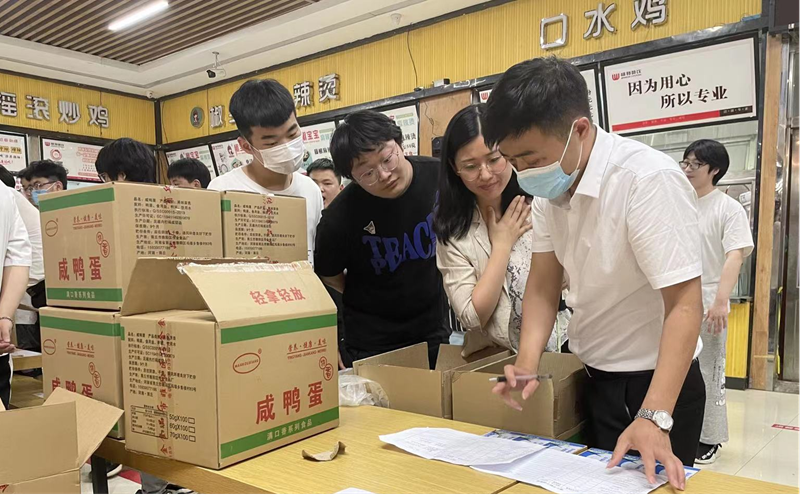 后勤处工作人员为同学们发放咸鸭蛋