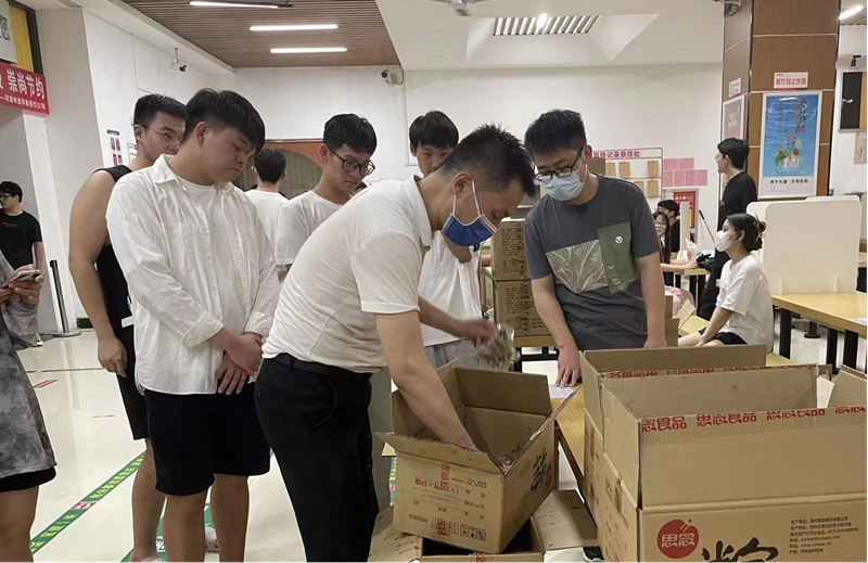 餐厅工作人员为同学们发放粽子